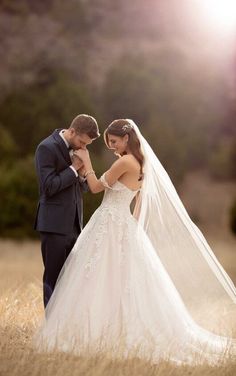 a bride and groom standing in the middle of a field