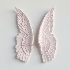 two white angel wings sitting on top of a table