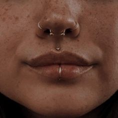 a woman with piercings on her nose and nose ring in front of her face