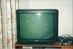 a television sitting on top of a wooden table