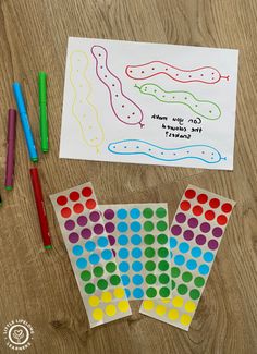 some paper and markers on a wooden table with a card that says can you match the colored dots?