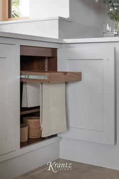 an open cabinet with towels hanging from it