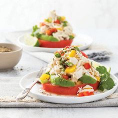 two white plates filled with salad on top of a table