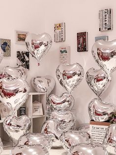 a table topped with lots of shiny heart shaped balloons