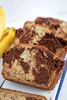 slices of chocolate marbled banana bread on a white plate next to a ripe banana