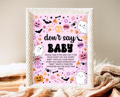 a pink halloween baby shower sign on a bed