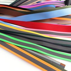 many different colored ribbons are stacked on top of each other