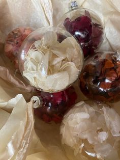 three ornaments are sitting on the table together, one is filled with gummy bears