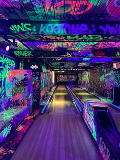 a bowling alley with neon lights and graffiti on the walls