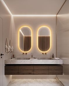 a bathroom with two sinks, mirrors and lights on the wall above it's counter