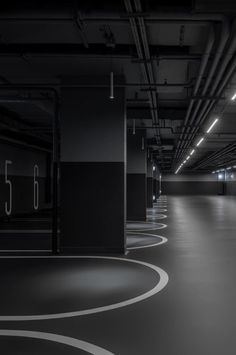 an empty parking garage filled with lots of black and white flooring in the dark