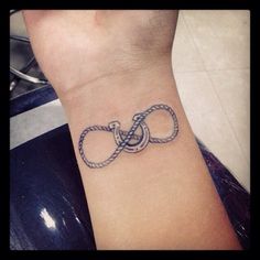 a tattoo on the wrist of a woman with an infinite knot in it's middle