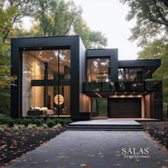 a modern house in the woods with lots of windows and glass doors on each side