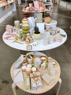 two tables with candles, cards and other items on them in a room full of shelves