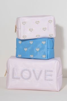 Carry all your odds and ends in style with Shiraleah's "Love" Zip Pouch. Made of durable polyester in light pink, this rectangular case is the perfect size to sit in a drawer or be carried on the go. The chic embroidered faux pearls spell out the word "Love" which make it the perfect pouch to take with you wherever you go. Pair with other items from Shiraleah to complete your look! Features A Top Zip Closure And Embroidered Faux Pearl Design Shiraleah Is A Trend-Driven Lifestyle Brand Focused On The Little Gifts That Make Life Special! Made From Polyester And Faux Pearls Measures L 9.5" X W 4" X H 6" Made In China Pink Rectangular Pouch For Storage, Pink Rectangular Cosmetic Bag For Storage, Pink Rectangular Cosmetic Bag, Pink Rectangular Pouch, Trendy Pink Cosmetic Bag For Storage, Pink Rectangular Pouch For Personal Use, Pink Travel Pouch Rectangular Case, Rectangular Pink Pouch For Personal Use, Pink Rectangular Travel Pouch