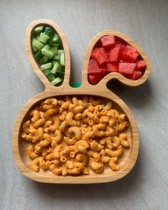 two wooden bowls filled with food on top of a gray tablecloth covered flooring