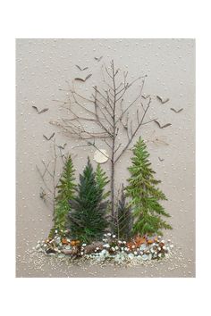 a group of trees sitting next to each other in front of a wall with birds flying over them