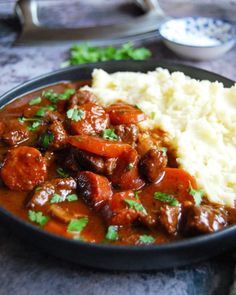 a plate with mashed potatoes, meat and gravy