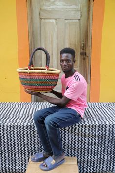 a man sitting on a bench holding a basket