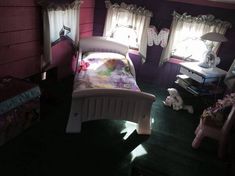 a bedroom with purple walls and green flooring, two small children's beds in the corner