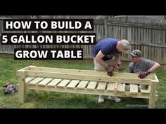 two men working on a wooden bench with text overlay how to build a 5 gallon bucket grow table