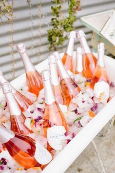 there are many bottles of wine in the ice cubes on the table with flowers