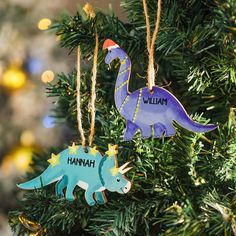 two dinosaur ornaments hanging from a christmas tree