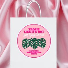 a white bag with pink and green stickers on it that says tropic like it's hot