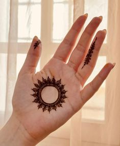 a woman's hand with hennap on it in front of a window