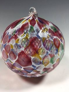 a glass ornament with multicolored designs on it