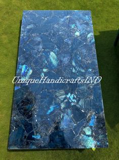 a blue marble table top sitting on the grass