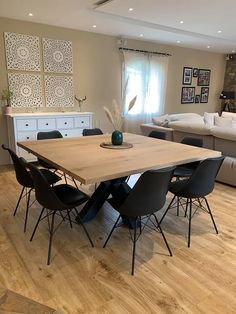 a dining room table with chairs and a couch in the background