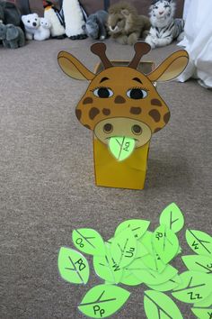 a cardboard giraffe head with numbers cut out on the floor next to it