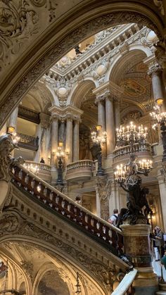 an ornate building with chandeliers and marble stairs