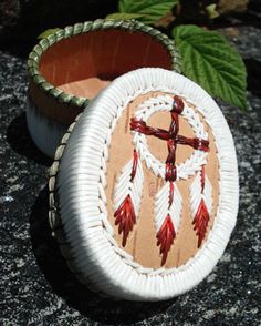 a small wooden box sitting on top of a stone floor next to a leafy plant