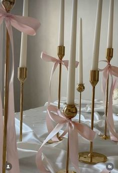 several candles with pink bows on them are lined up