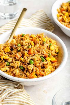 two bowls filled with rice and vegetables on top of a table