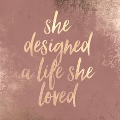 the words she designed a life she loved are painted in gold on a pink background