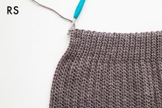 a knitted piece of cloth with a blue hook on it and the words, how to crochet for beginners