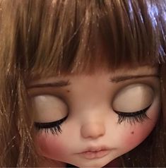 a close up of a doll with long eyelashes