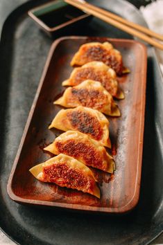 some dumplings are on a plate with chopsticks