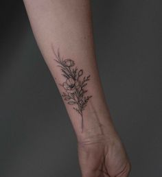 a small flower tattoo on the wrist