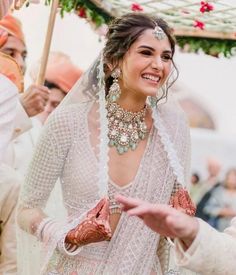 a woman in a wedding dress is smiling and talking to another woman wearing a veil