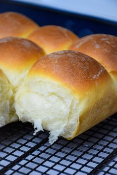 the buns have been cut in half and are sitting on a cooling rack with text overlay that reads, sweet dinner rolls