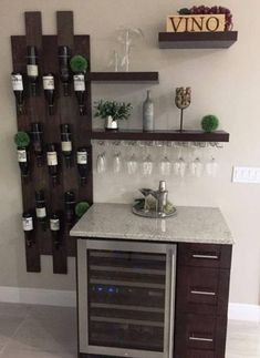 a wine rack with bottles and glasses on it next to a wall mounted wine glass holder