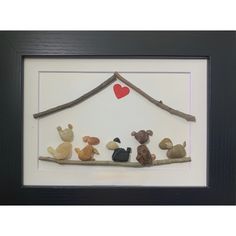 a group of stuffed animals sitting on top of a wooden branch with a heart above it