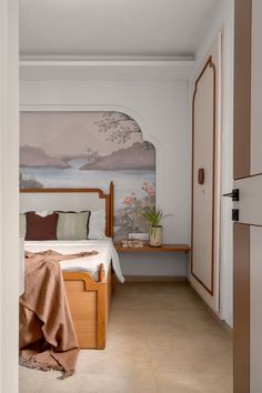 a bed room with a neatly made bed and a painting on the wall