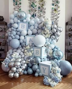 an arrangement of balloons, flowers and letters are arranged on the floor