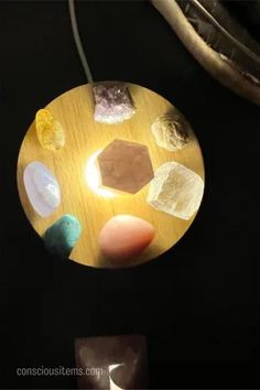 a wooden plate with different types of rocks on it and a light in the middle