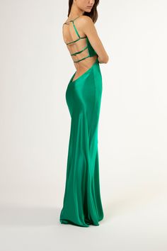 a woman in a long green dress with open back and cut outs on the side